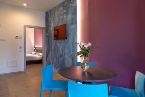 a vase of flowers on a table with blue chairs at Residence Solei Classic & Plus in Brenzone sul Garda