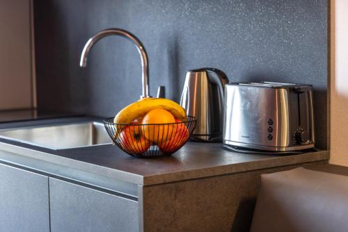 a bowl of fruit sitting on a counter next to a sink at Residence Solei Classic & Plus in Brenzone sul Garda
