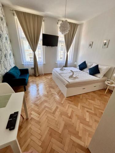 une chambre avec un lit blanc et un parquet dans l'établissement Studio Oliver, à Prague