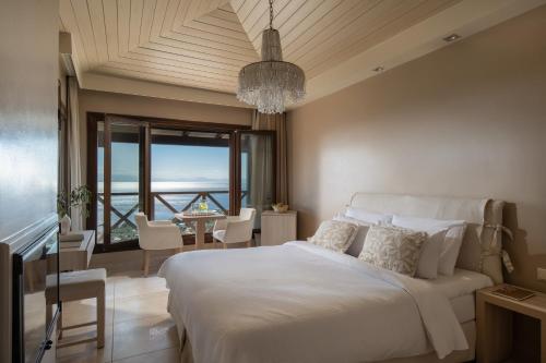 a bedroom with a large bed and a dining room at Karavia Lux Inn in Afissos