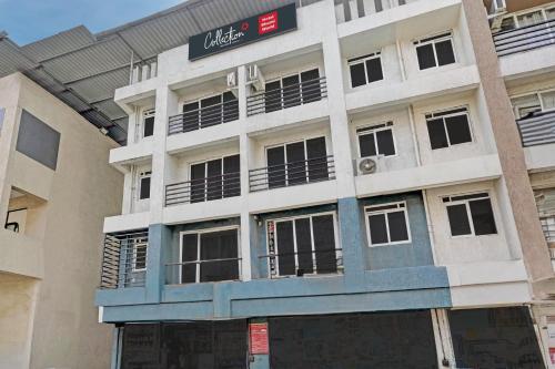 a white building with a sign on top of it at Hotel O Bhumi World in Bhiwandi