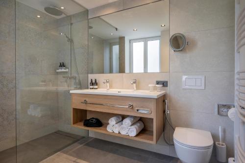 a bathroom with a sink and a shower and a toilet at Hotel IMLAUER & Bräu in Salzburg