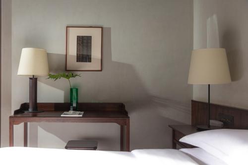 a bedroom with two lamps and a table with a bed at Lijiang Old Town Lanshe hotel in Lijiang