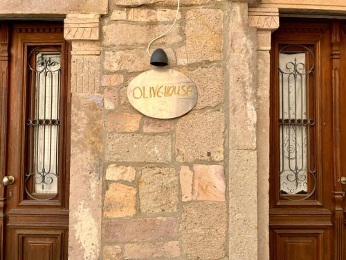 a sign on the side of a building with two doors at Olive House in Polichnítos
