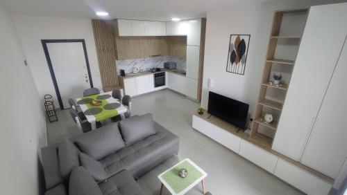 a living room with a couch and a table and a kitchen at Golem Horizon apartment in Golem