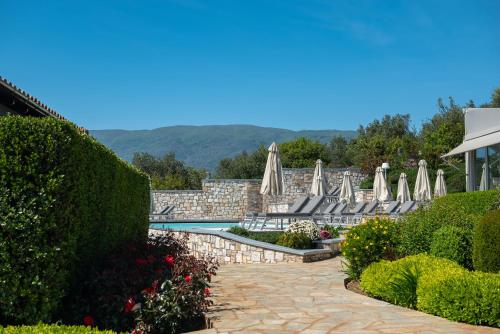 a patio with umbrellas and a swimming pool at Karavia Lux Inn in Afissos