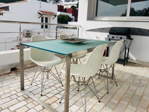 a glass table and chairs on a patio at Villa Rosita Ibiza in Talamanca