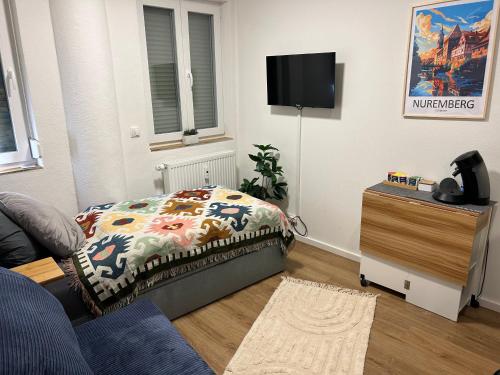 a living room with a bed and a tv at ModernesMiniZimmer-Stadtnah-SelfCheckIn-Parkplatz in Nürnberg
