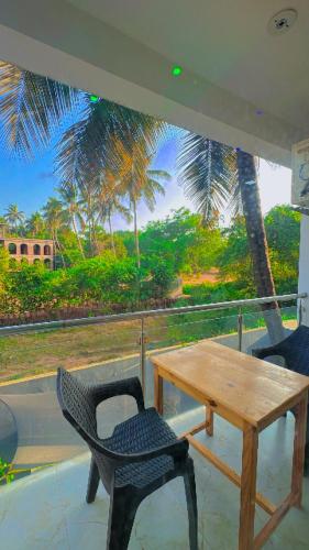 a table and a chair on a balcony with a view at Seaside Stay in Arambol