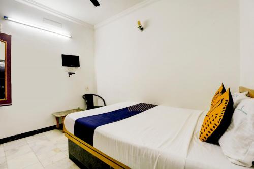 a bedroom with a bed and a tv on the wall at SPOT ON JAYAM RESIDENCY in Chennai