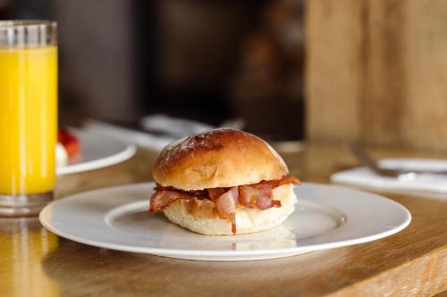 a sandwich on a plate next to a glass of orange juice at Shepherds Huts at The Cornish Arms in St Merryn