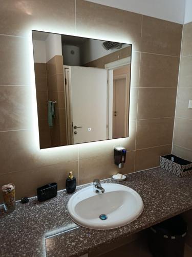 a bathroom sink with a large mirror above it at Golden Panorama in Novalja