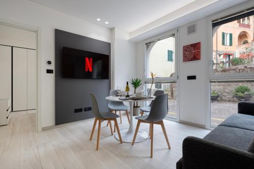 a living room with a tv and a table and chairs at Elysium I in Noli