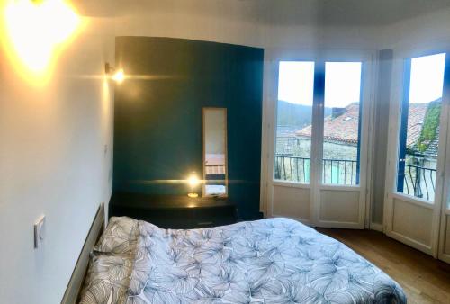 ein Schlafzimmer mit einem Bett und zwei großen Fenstern in der Unterkunft Chambre SIGOU in Sigoulès