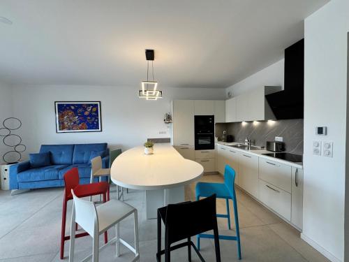 une cuisine et un salon avec une table et des chaises dans l'établissement Appartement 225, CORAL à la plage de la Conque, au Cap d'Agde