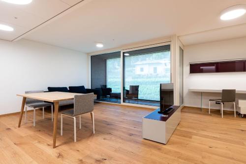 an office with a table and chairs and a tv at Modern, simple and super-equipped style apartment in Stabio