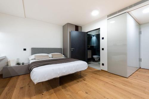 a bedroom with a large bed and a bathroom at Modern, simple and super-equipped style apartment in Stabio