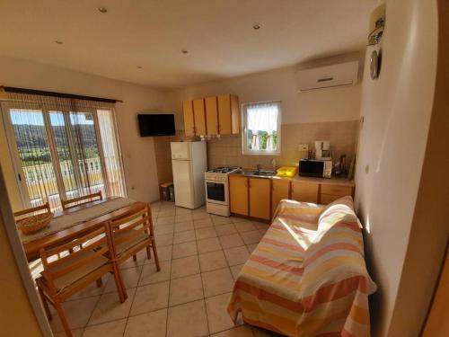 a kitchen with a table and a couch in it at Apartments Kampor (4235) in Kampor