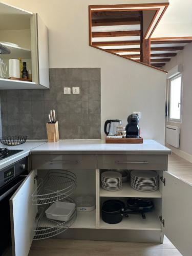 - une cuisine avec comptoir et vaisselle dans l'établissement Duplex hyper centre Saint-Vit!, à Saint-Vit