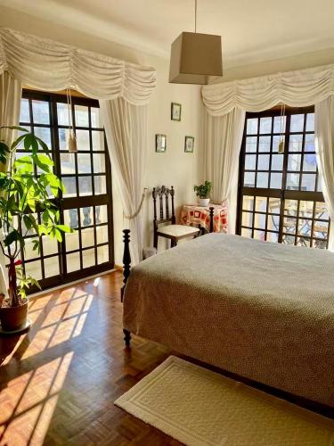 a bedroom with a bed and two large windows at Spray B&B Sitio in Nazare, European style in Nazaré