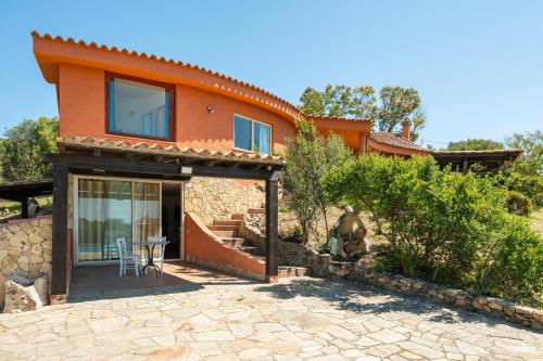 an orange house with a table in front of it at Harmònia Residence in Villasimius