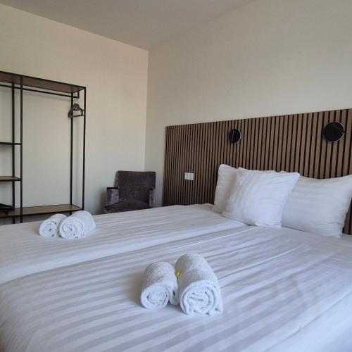 a hotel room with a bed with towels on it at Hotel Den Burg in Den Burg