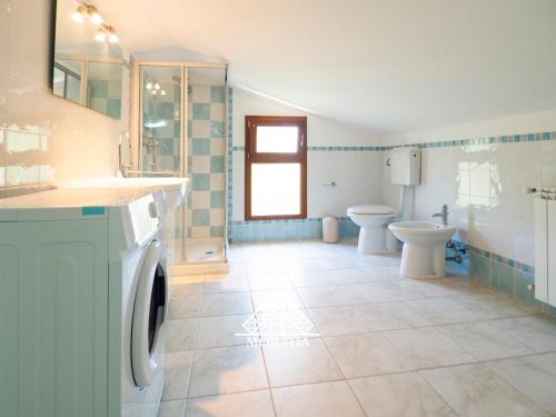 un bagno con lavatrice e WC di Casa Maura - MORADA a Iglesias
