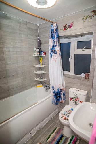 a bathroom with a tub and a toilet and a sink at Charming London Guest Room with Garden BBQ in London