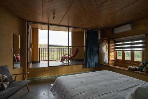 a bedroom with a bed and a balcony at Chuồn Chuồn Retreat in Phan Thiet