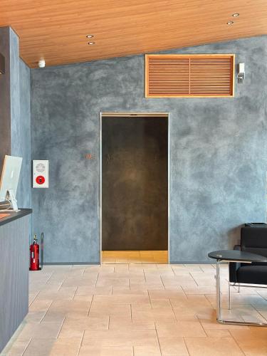 a door in a room with a table and chairs at 白水温泉竹の倉山荘 in Minami Aso