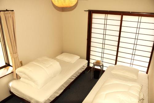 a small room with two beds and a window at Traditional Japanese House -in Matsumoto Asama Onsen- in Matsumoto