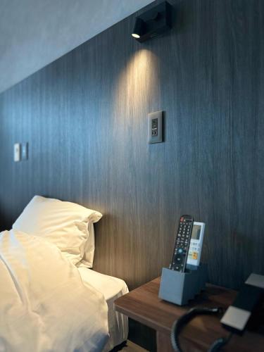 a bedroom with a bed and a desk with a remote control at 白水温泉竹の倉山荘 in Minami Aso