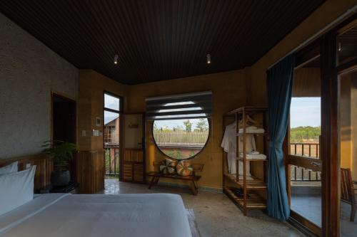 a bedroom with a bed and a large mirror at Chuồn Chuồn Retreat in Phan Thiet