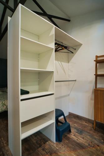 une étagère blanche dans une pièce avec une chaise bleue dans l'établissement O Cabanon Maison COSY à moins de 300m de la Plage, à Sainte-Marie-la-Mer