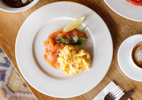 a white plate with food on a table at Shepherds Huts at The Cornish Arms in St Merryn
