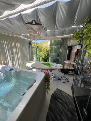 - une grande baignoire dans une chambre avec tente dans l'établissement La Maison Du Bonheur, à Saintry-sur-Seine