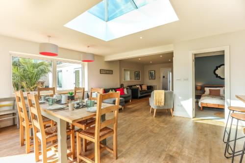 a dining room and living room with a table and chairs at Iona – Bracklesham Bay in Chichester