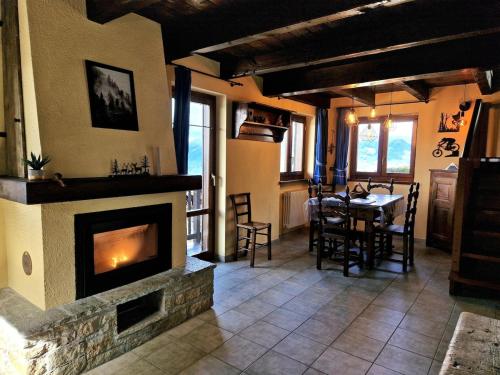 un soggiorno con camino e tavolo con sedie di Chalet Grande Cerise - vicino ad Aosta e Pila a Gressan