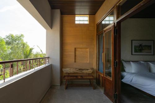 a bedroom with a bed and a balcony at Chuồn Chuồn Retreat in Phan Thiet