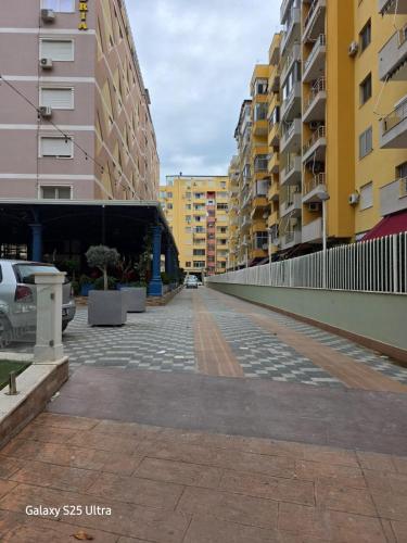 an empty street in a city with tall buildings at Cappuccino Apartment Shengjin in Shëngjin