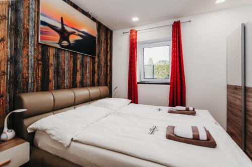a bedroom with a large bed with red curtains at NaturparkResort Salzahalt in Wildalpen
