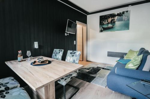 a dining room with a wooden table and a blue couch at NaturparkResort Salzahalt in Wildalpen
