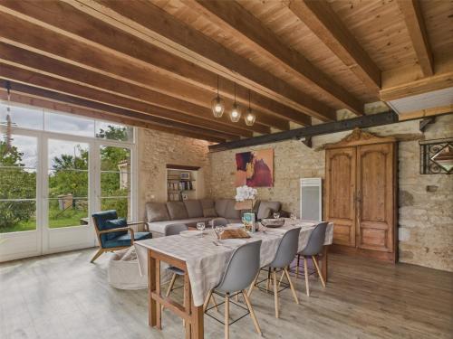 une grande salle à manger avec une table et des chaises dans l'établissement Maison authentique en pierre pour 7 avec jardin, à Saint-Vincent-sur-Jard