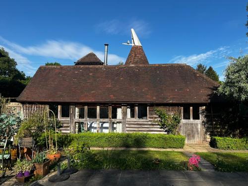 an old house with a roof and a yard at Cart Shed Heaven in Sissinghurst