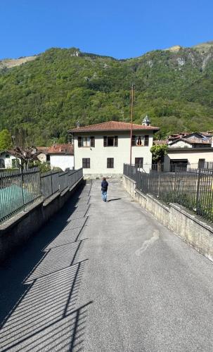 a person walking down a road next to a building at Marisa's home in Barni