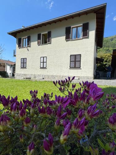 a house with purple flowers in front of it at Marisa's home in Barni