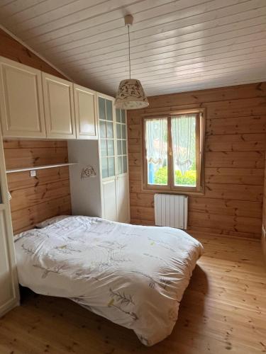 une chambre avec un lit dans une pièce en bois dans l'établissement Villa de charme en bois avec Piscine privée calme et proche de Toulouse, à Pibrac