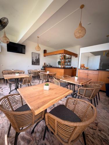 a dining room with wooden tables and chairs at Nikoli Apartments in Benitses