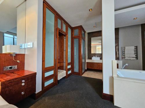 a bathroom with a tub and a sink and a mirror at Exquisite Penthouse Apartment 712 at La Montagne by First Private Stays in Ballito