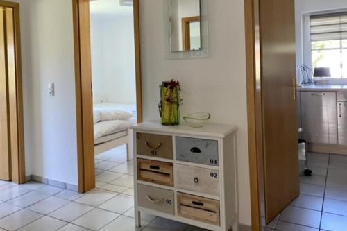 a dresser with a vase on it in a room at Kamin, Wintergarten & Sonnenterrasse in Wenkendorf auf Fehmarn